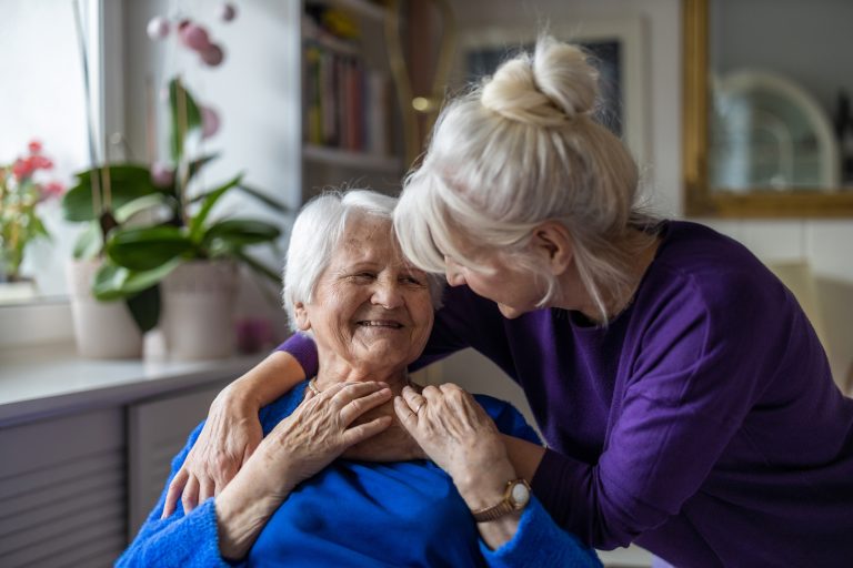 Older woman and her caregiver embracing