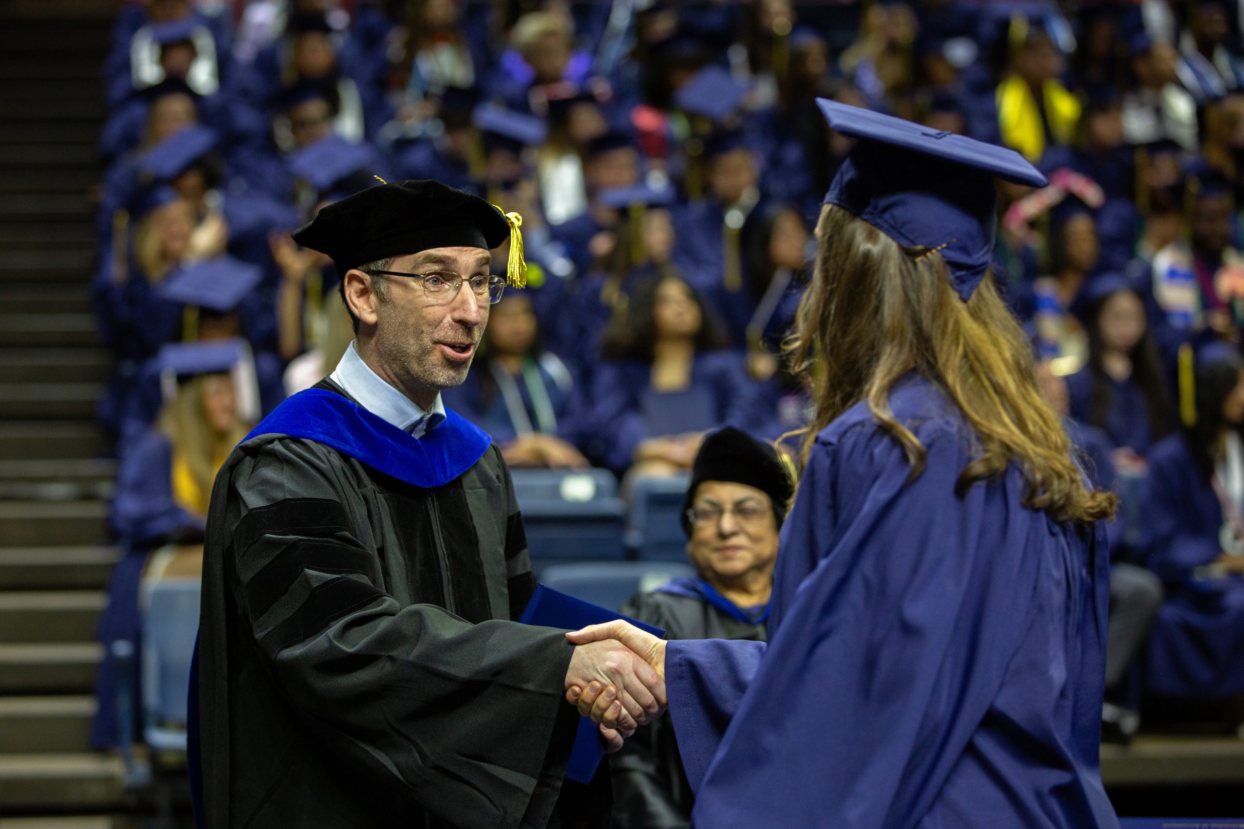 Dean Ofer Harel hands out diplomas at the College of Liberal Arts and Sciences commencement ceremony one in Gampel Pavilion.