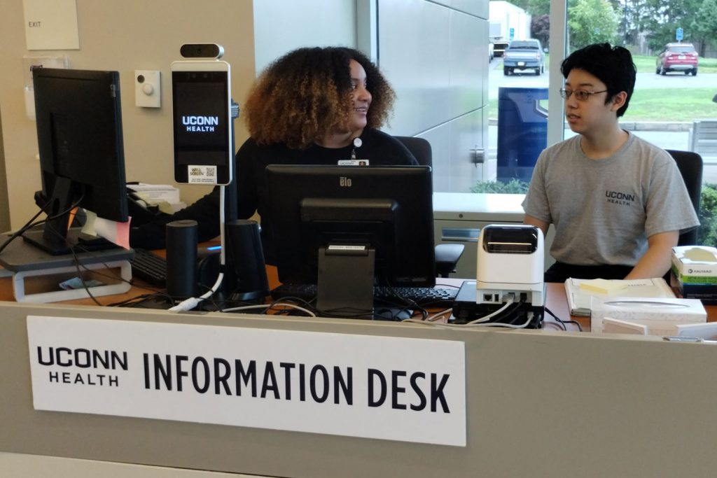 Volunteer and employee interact at information desk