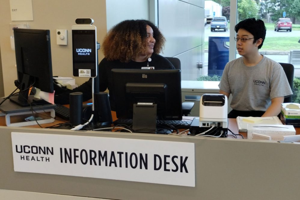 Volunteer and employee interact at information desk