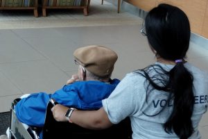 Female volunteer pushes a visitor in a wheelchair