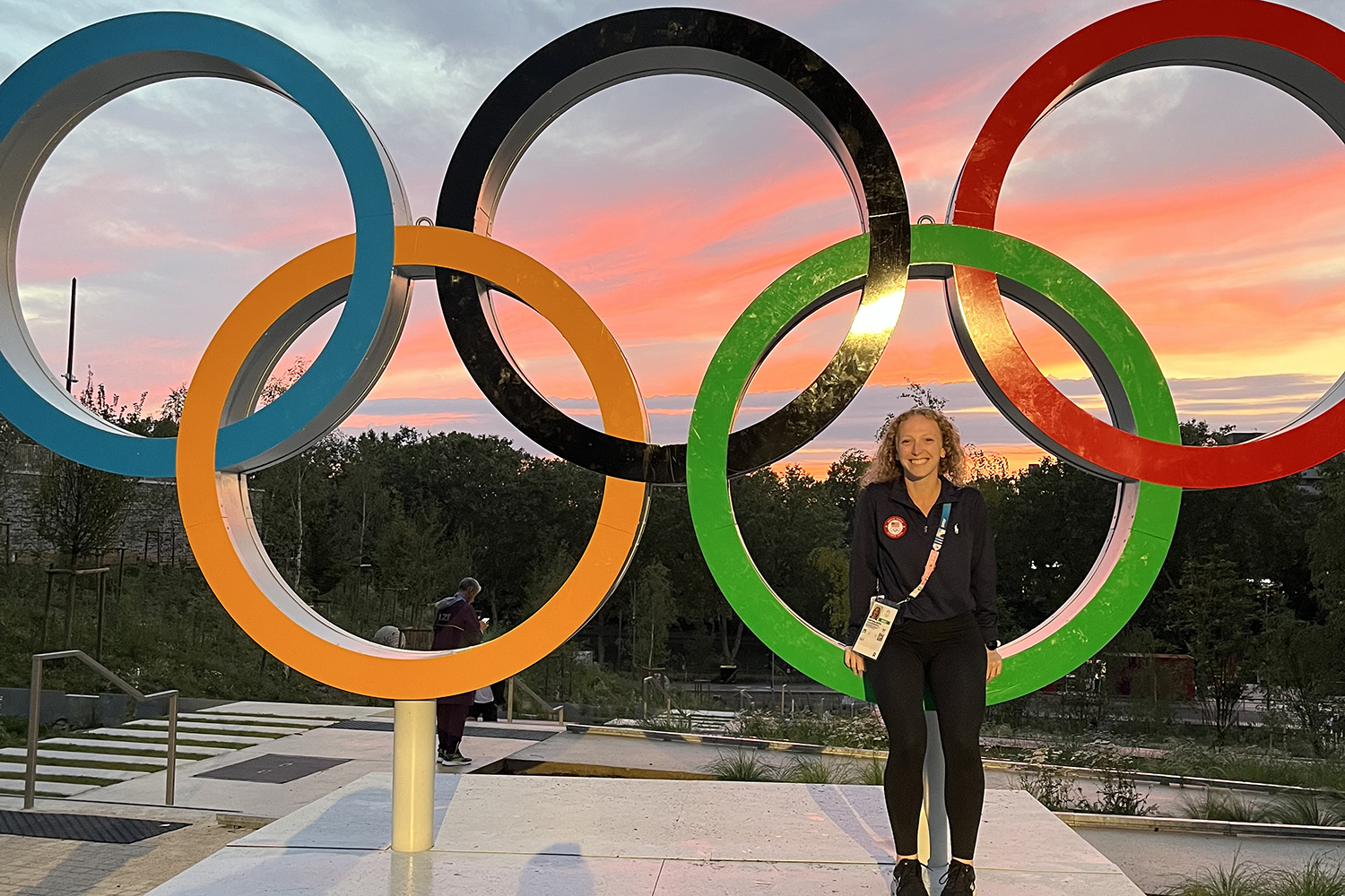 Kelli Bates standing in front of Olympic rings in Paris, France.