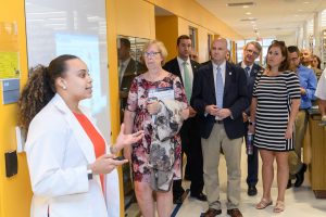 Stephany Santos and state leaders in a research lab.