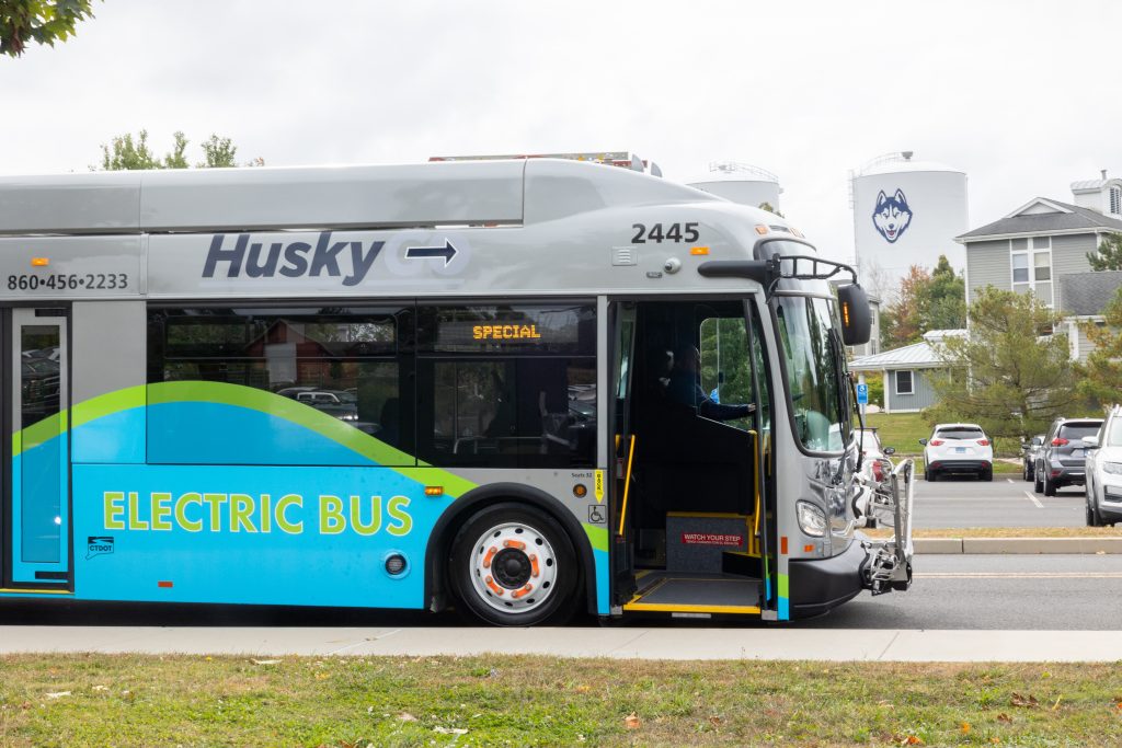 The new HuskyGo electric bus—the first of its kind in its fleet—sits next to the bus stops in the W Lot