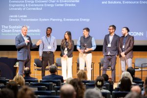 The winners of the Clean Energy and Sustainability Innovation Program (CESIP) Student Challenge Award stand onstage with Bill Quinlan, left, president of transmission & offshore wind projects for Eversource Energy, during the Sustainable Clean Energy Summit in the Student Union Theater