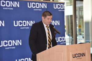 Male professional gives remarks at a podium. 