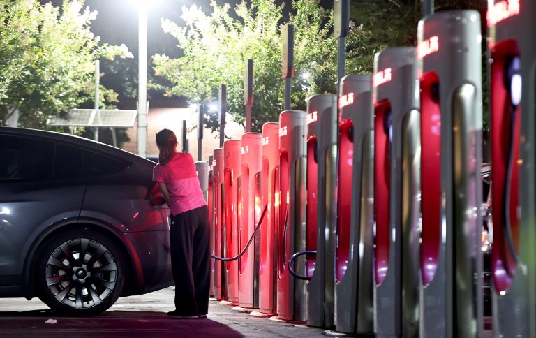 A driver recharges her electric vehicle.