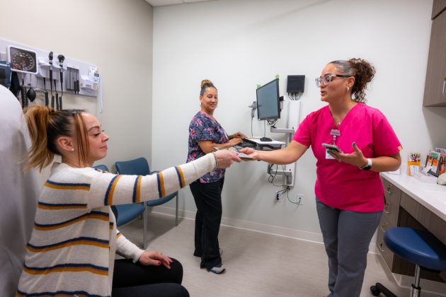 Medical assistants interacting with a patient in an exam room