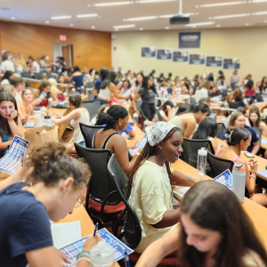 School of Nursing freshmen gathered in auditorium during Weekend of Welcome conversing amongst themselves