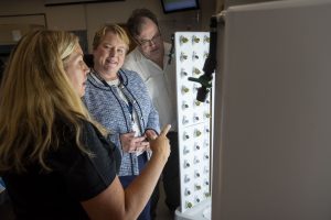 At center, Jennifer E. Orlikoff Dean and Chief Administrative Officer of UConn Stamford talking with Assistant Professor Laura Bunyan and lecturer, Roderick Wilson about the Flex Farm at UConn Stamford