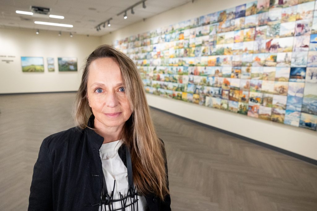 Artist Blanche Şerban poses for a photo among her artwork that is featured in the Jorgensen Gallery's current exhibition, "A Year of Plein Art Painting on Horsebarn Hill."