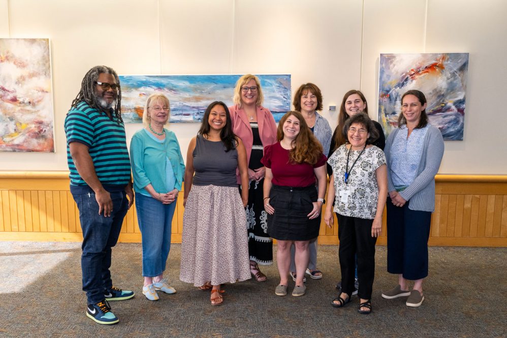 group portrait of art committee in front of some paintings