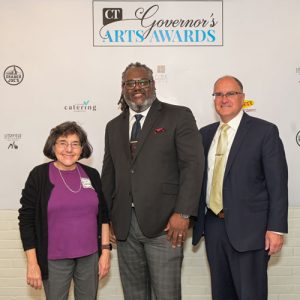 Group portrait of three in front of "CT Governor's Arts Awards" banner