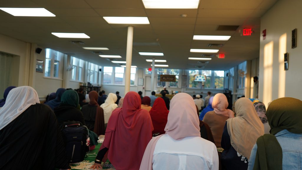 A group of students wearing head coverings sits together in the ICUC building.