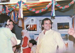 A group of smiling people in front of colorful streamers