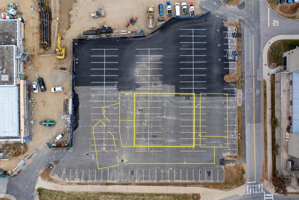 A view of yellow lines painted over the top of parking spaces at S Lot show the outline of the new School of Nursing Building