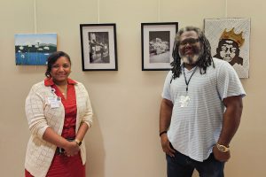 portrait of woman and man standing in front of paintings