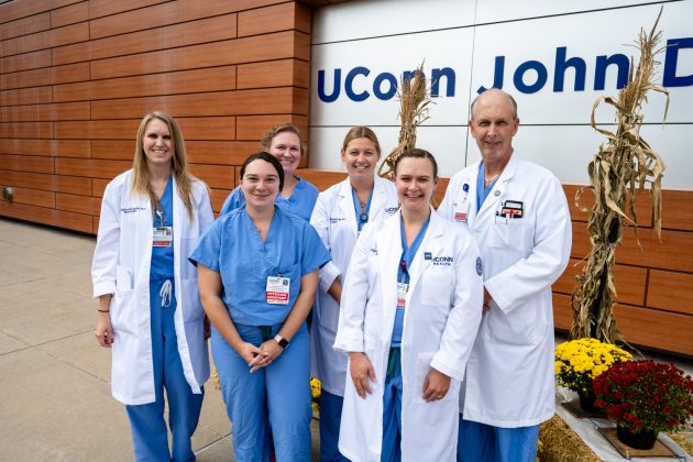 group portrait of six physician assistants in front of UConn John Dempsey Hospital sign