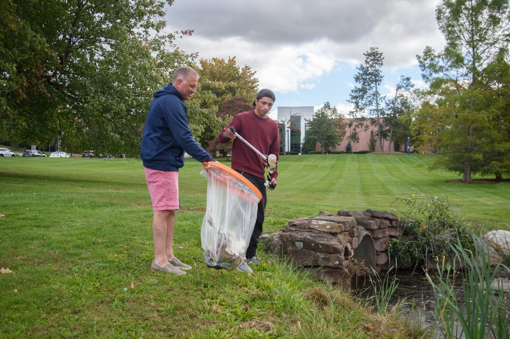 Jon Contaxis '25 (PHARM), right, and his father, Bill Contaxis '90 (ENG) of Milford, pick up trash around Mirror Lake