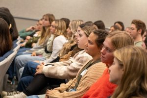 High school students sit in a lecture hall.