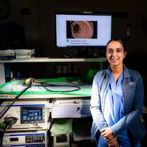 portrait of physician in OR in front of endoscopy equipment