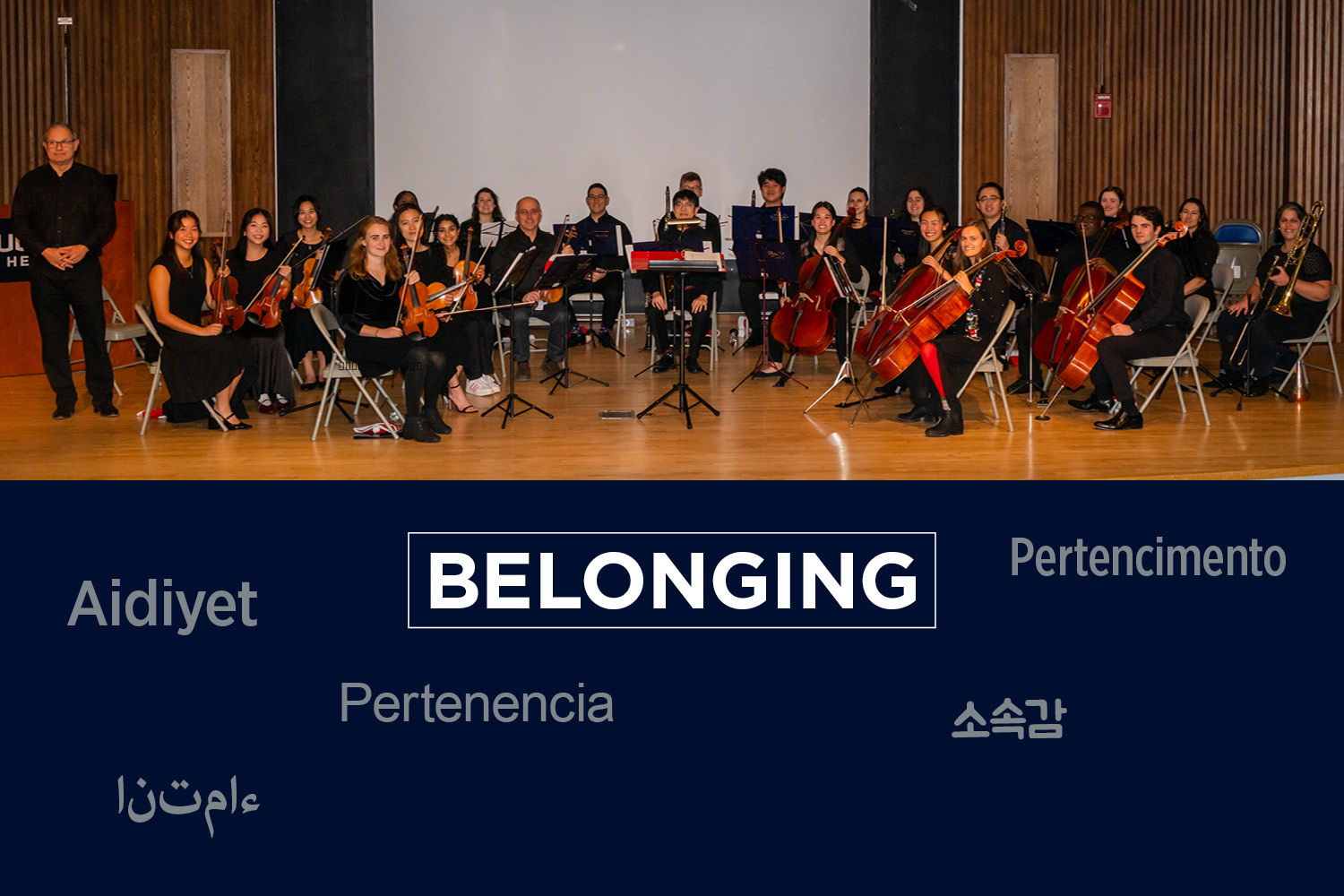 Portrait of orchestra on stage, with "Belonging" in several languages printed below