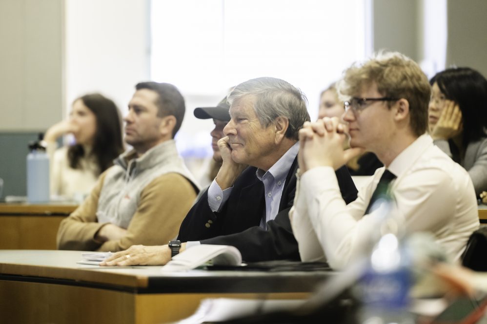 Dean Elliott with several students listening to a presentation at the Global Business Leadership in Sustainability Summit