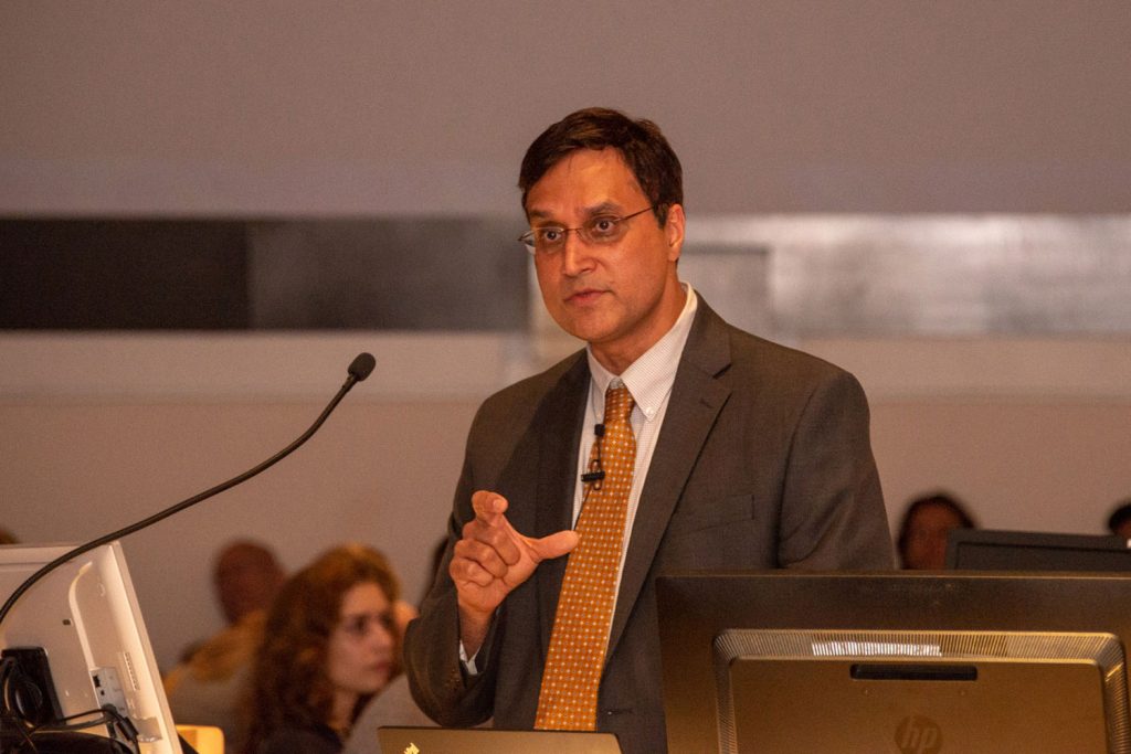 Dr. Ketan Bulsara speaking at lectern in academic rotunda