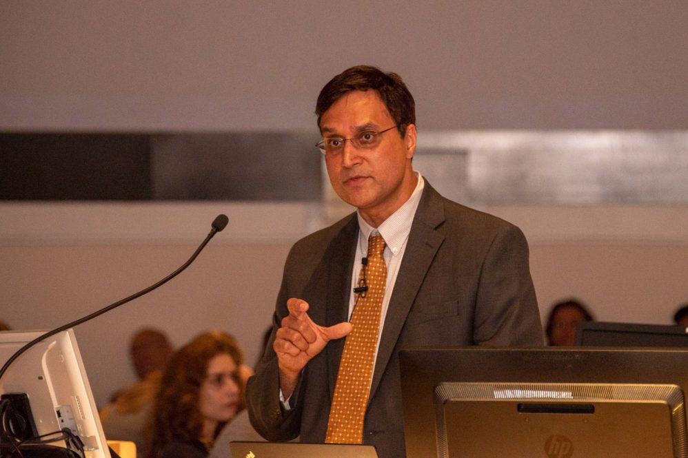 Dr. Ketan Bulsara speaking at lectern in academic rotunda