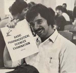 Student posing with an exam, 1980