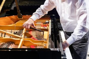 Piano technician John von Rohr uses a piano tuning hammer and mutes to tune the Jorgensen Center for the Performing Arts' new 2024 Steinway