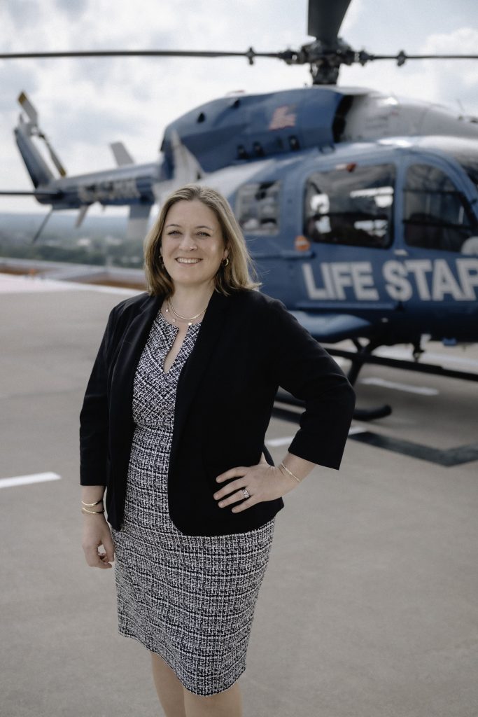 Patricia “Tricia” Margarido poses in front of the LIFESTAR helicopter. 