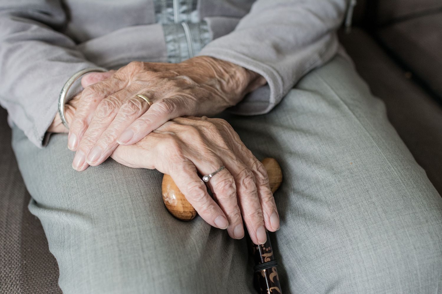 older woman's hands holding a cane