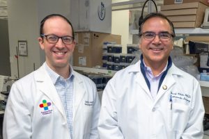 portrait of two men in lab coats at bench