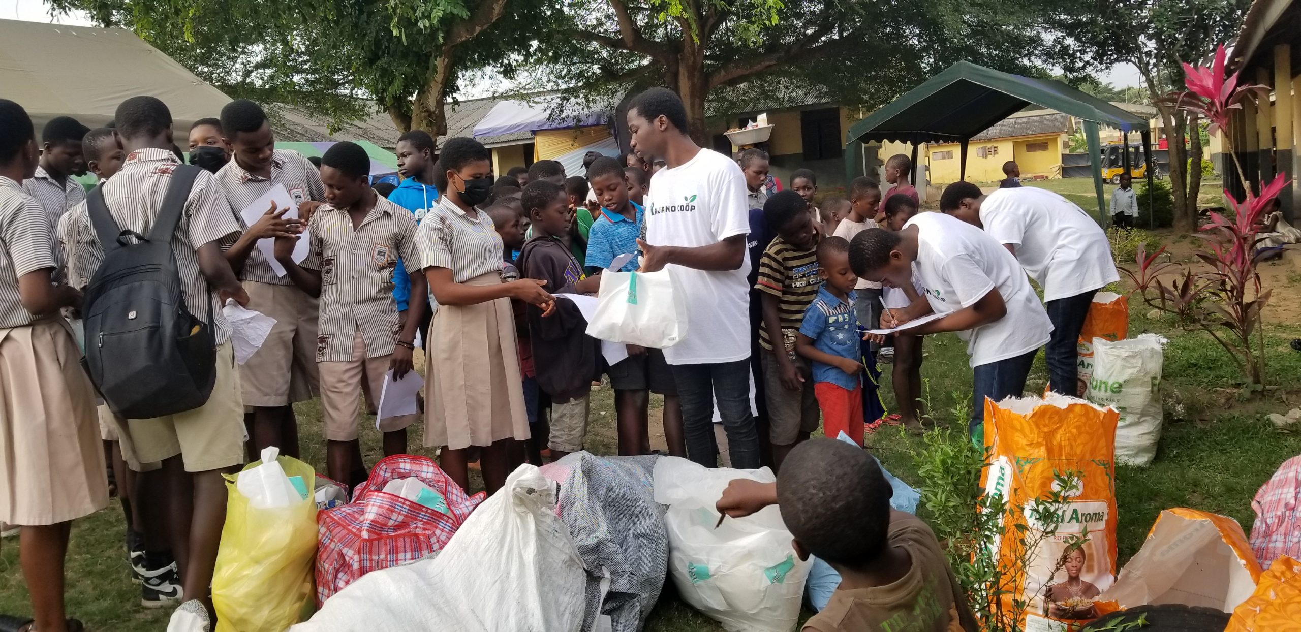 UConn student Anthony Mensah hands out food to a line of young people during a food drive in Accra, Ghana.