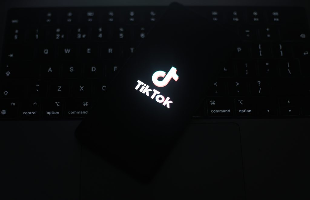 TikTok logo is displayed on a smartphone