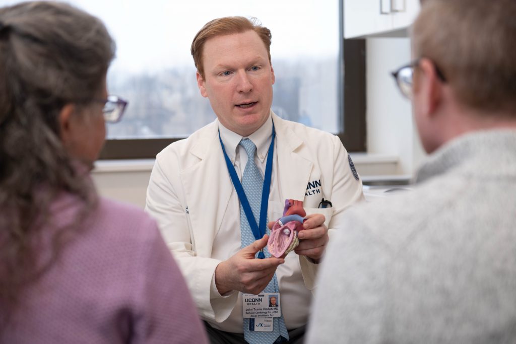 Dr. Travis Hinson speaking with a patient at the Calhoun Cardiology Center at UConn Health (Photo by JAX/Cloe Poisson).