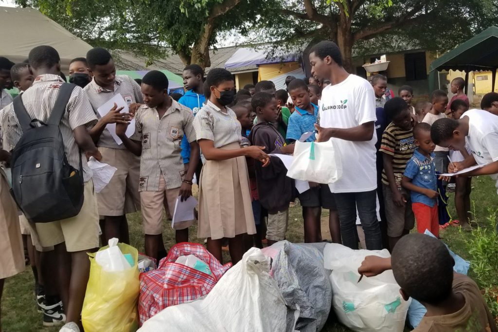 UConn student Anthony Mensah hands out food to a line of young people during a food drive in Accra, Ghana.