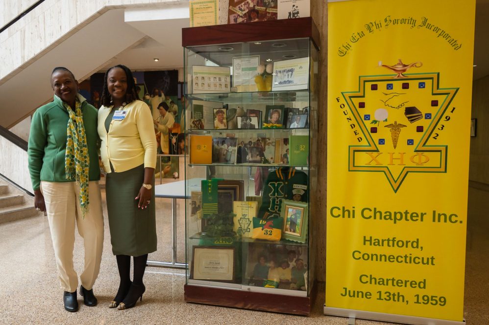 Two women standing beside a Black History Month display