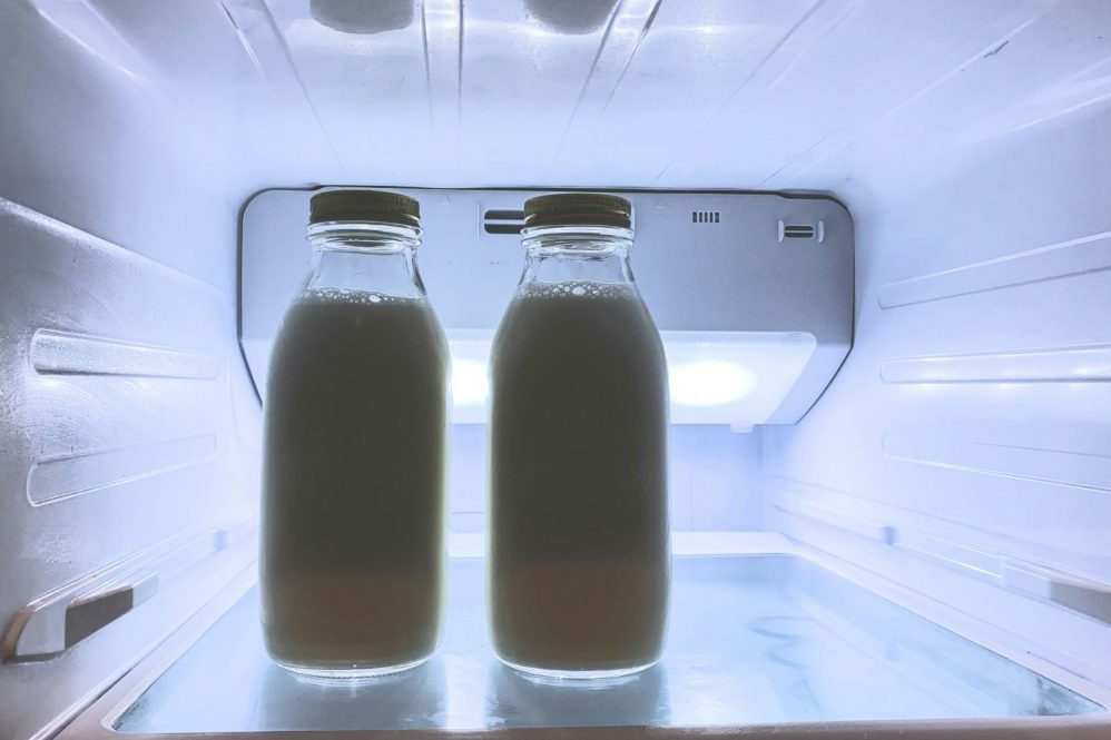 Two glass containers of mil in a refrigerator