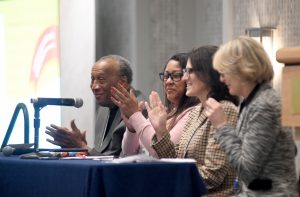 Four people sitting at a head table with microphones