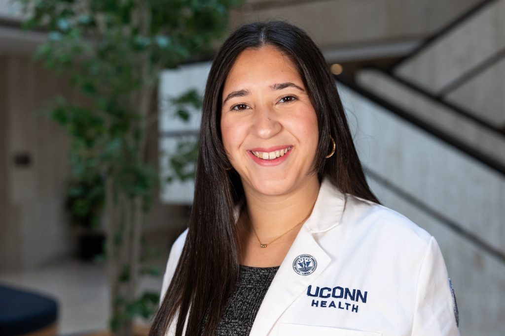 manda Hernández Rodríguez, a medical student wearing a white coat that says "UConn Health."