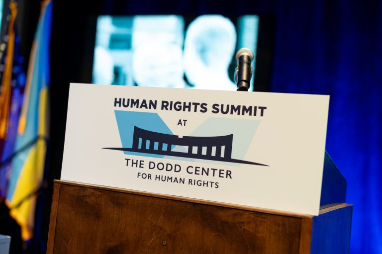 Photo of podium with sign that says Human Rights Summit at The Dodd Center