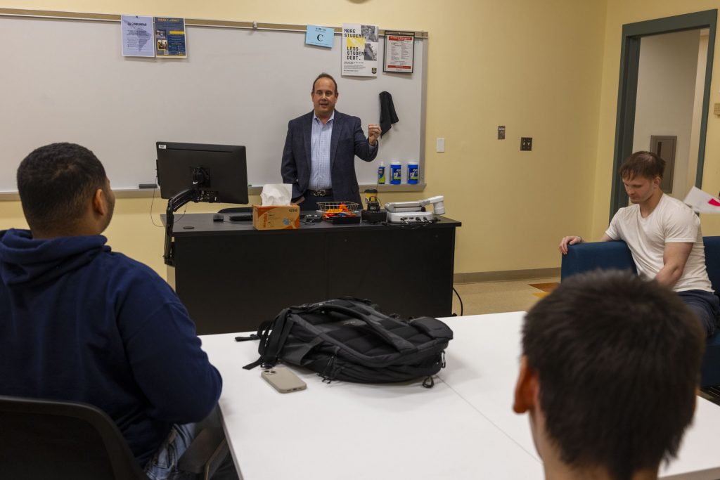 A man standing in front of a classroom, leading a discussion.