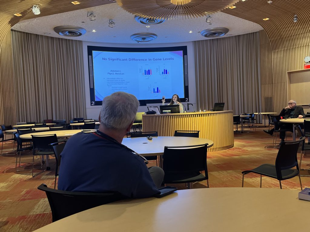 UConn Health's Dr. Thomas Regan looks on as his daughter Cailyn Regan presents her final capstone project and follows in his footsteps to become a physician.