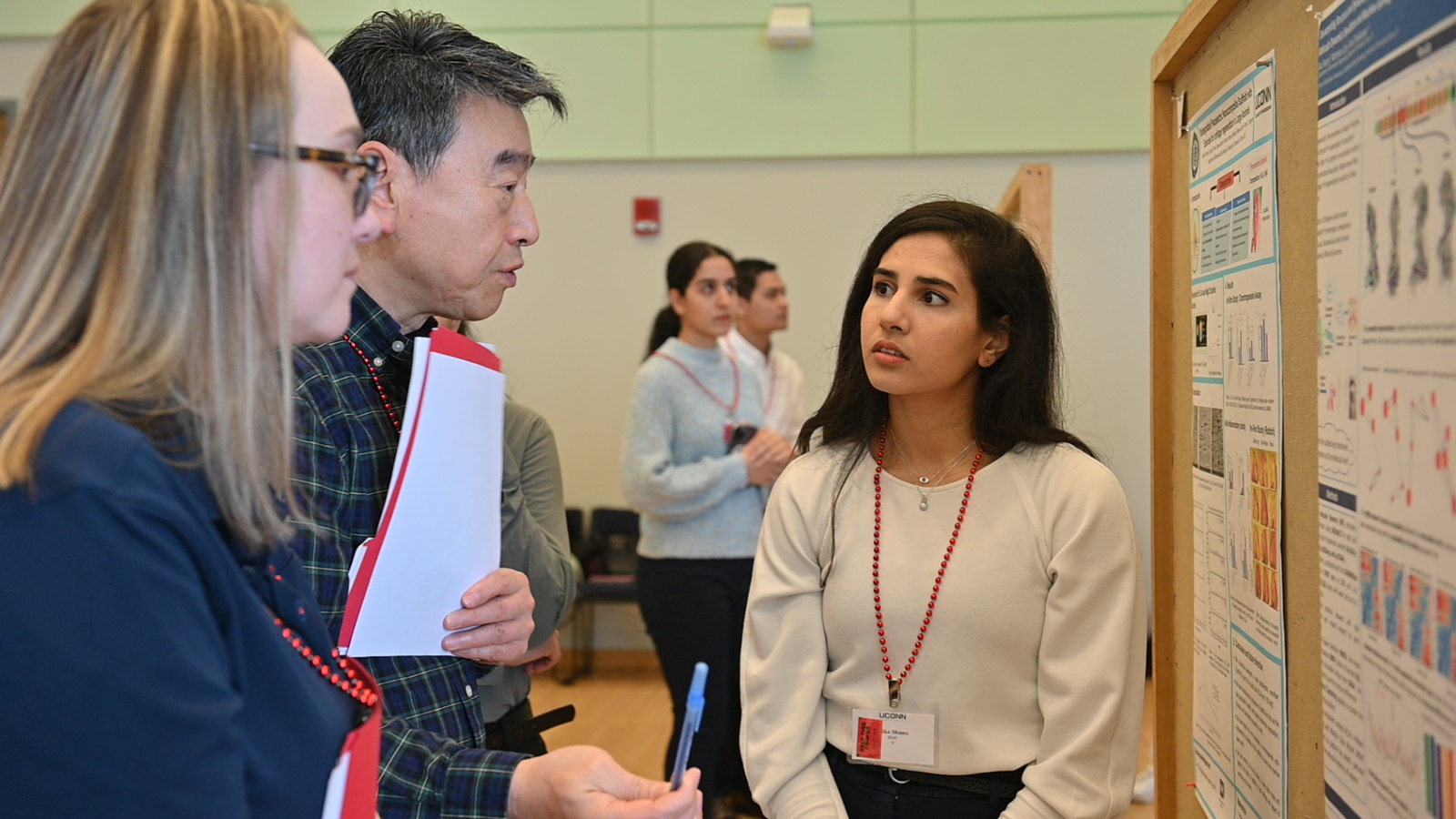 Photo of two judges reviewing a poster with the student.