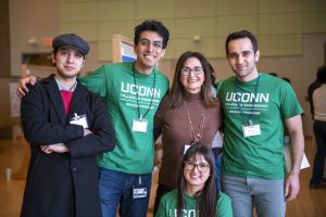 Student volunteers at the poster competition pose with Director Aida Ghiaei. 