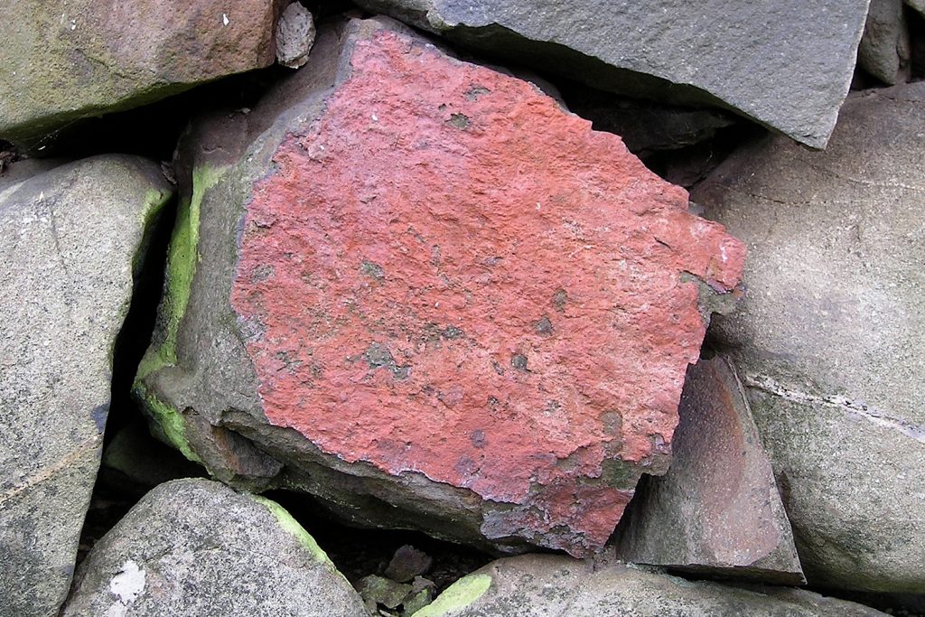 Red stone nestled among other stones