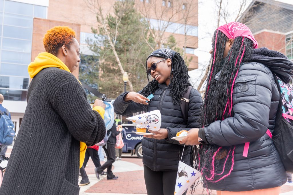 Ebonie Marie hadnign out affirmations to students on Fairfield Way