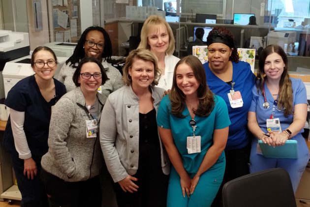 group portrait of eight women near nurse's station
